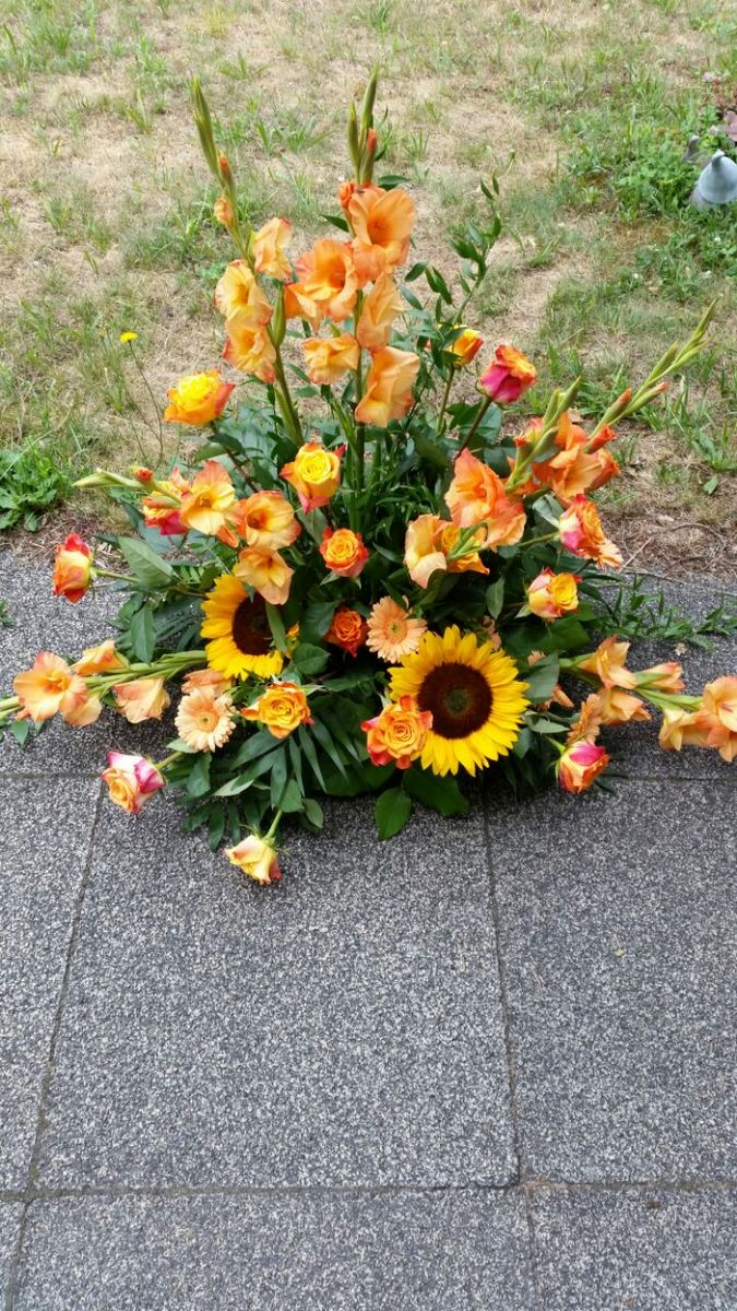 Bodengesteck in Orange und Gelb mit Gladiolen, Sonnenblumen und Rosen